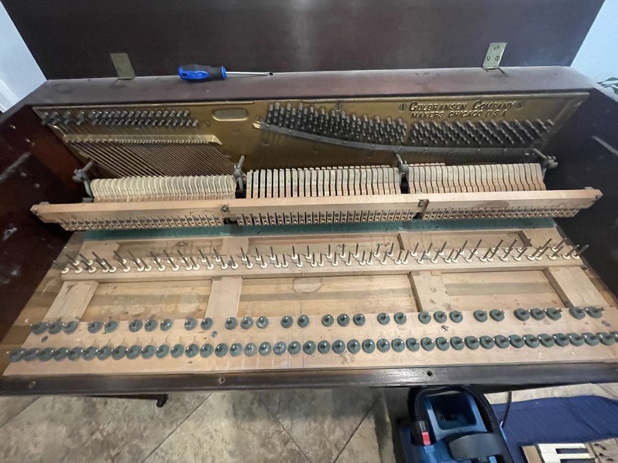 Inside of an upright piano after cleaning — clean wooden surfaces and refreshed action parts